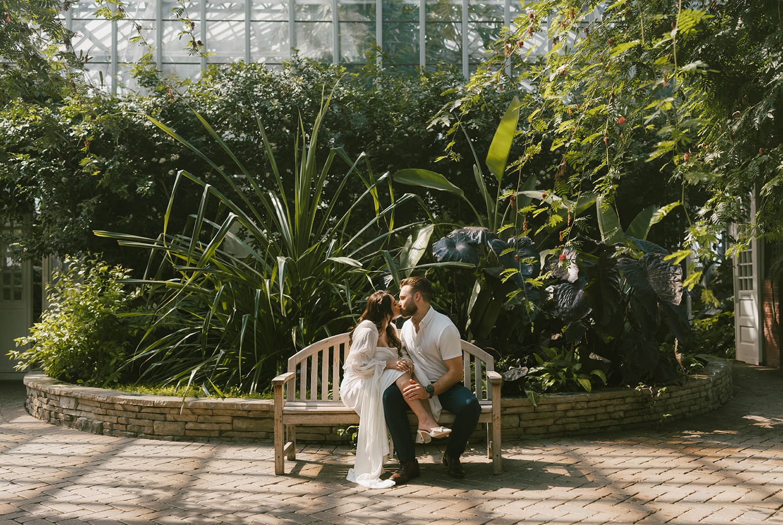 A couple kissing in greenhouse engagement photos
