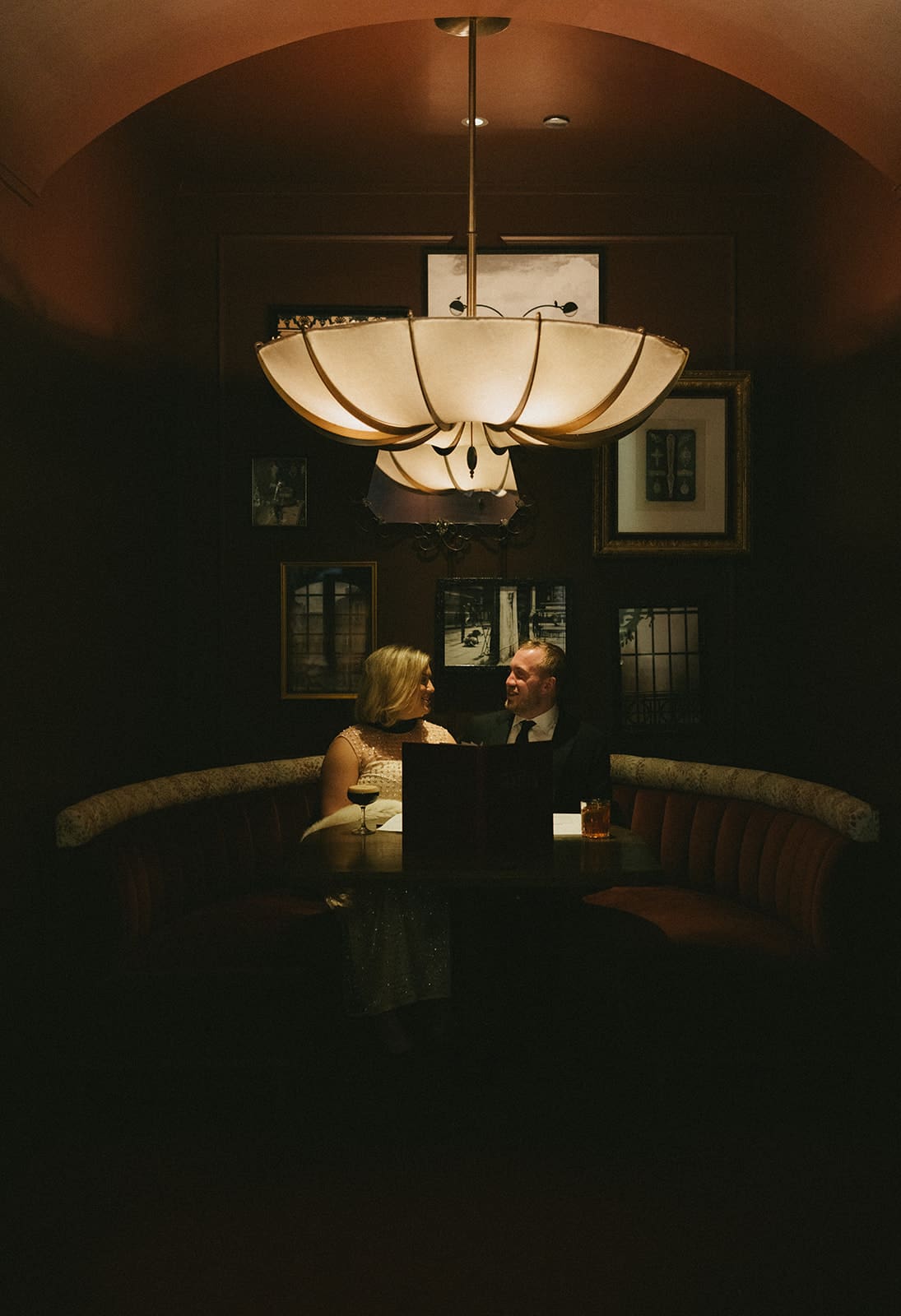 A couple taking winter engagement photos in a bar