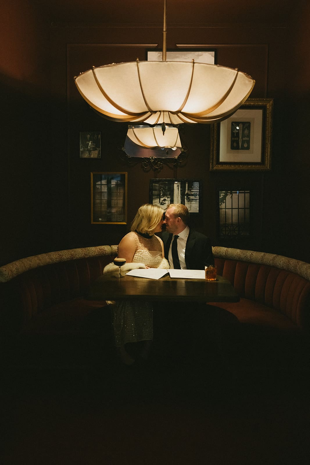 A couple taking winter engagement photos in a bar