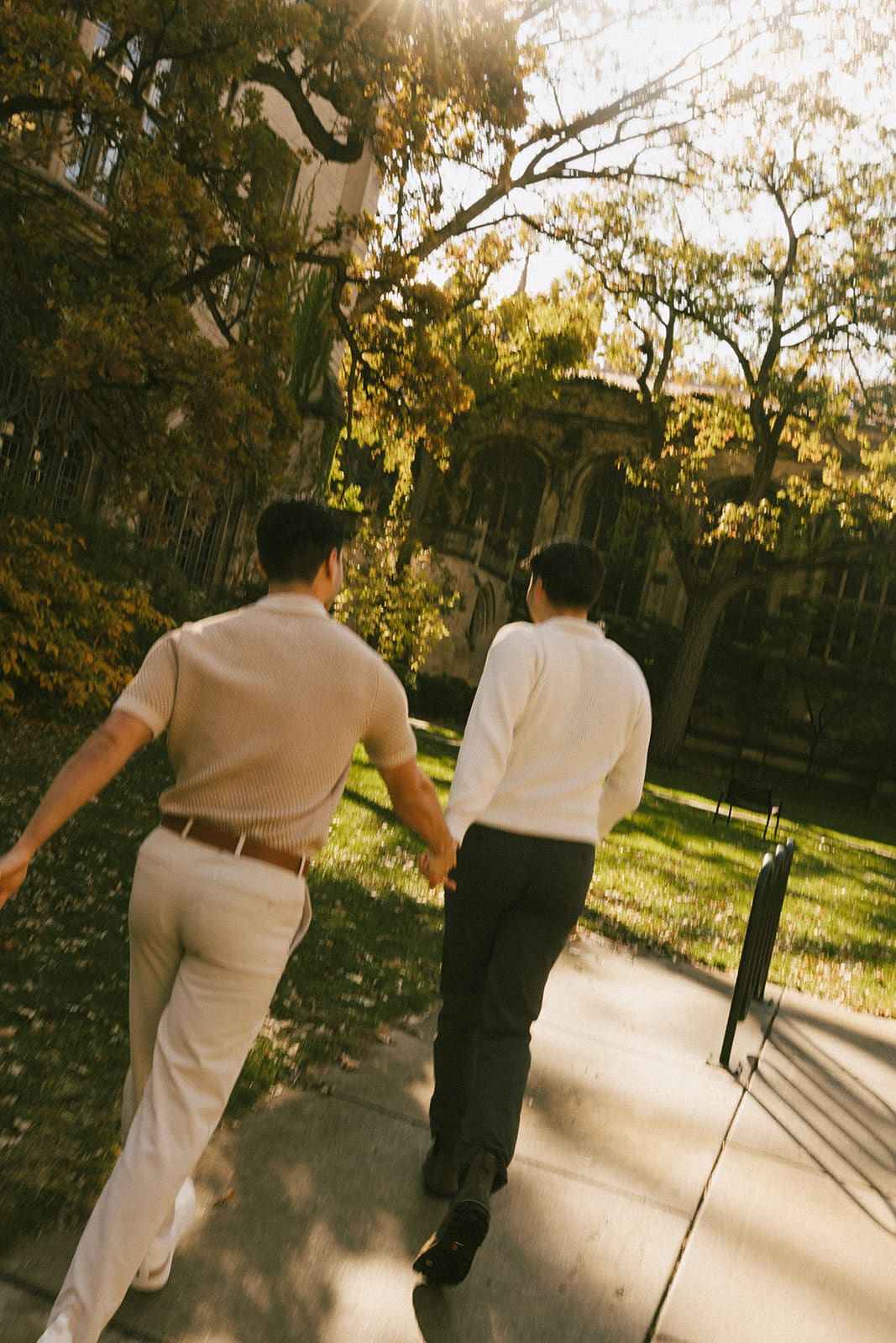 A couple posing for fall engagement photos at the university of chicago campus