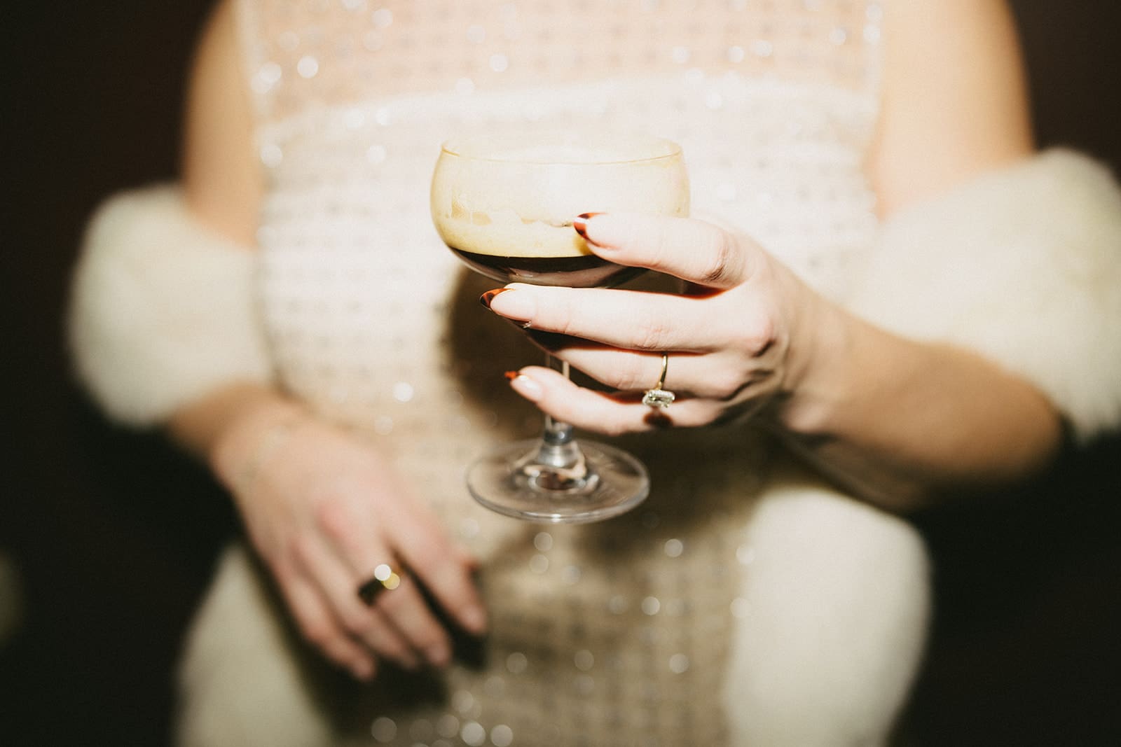 A woman wearing a sparkly dress and fur coat for winter engagement photos