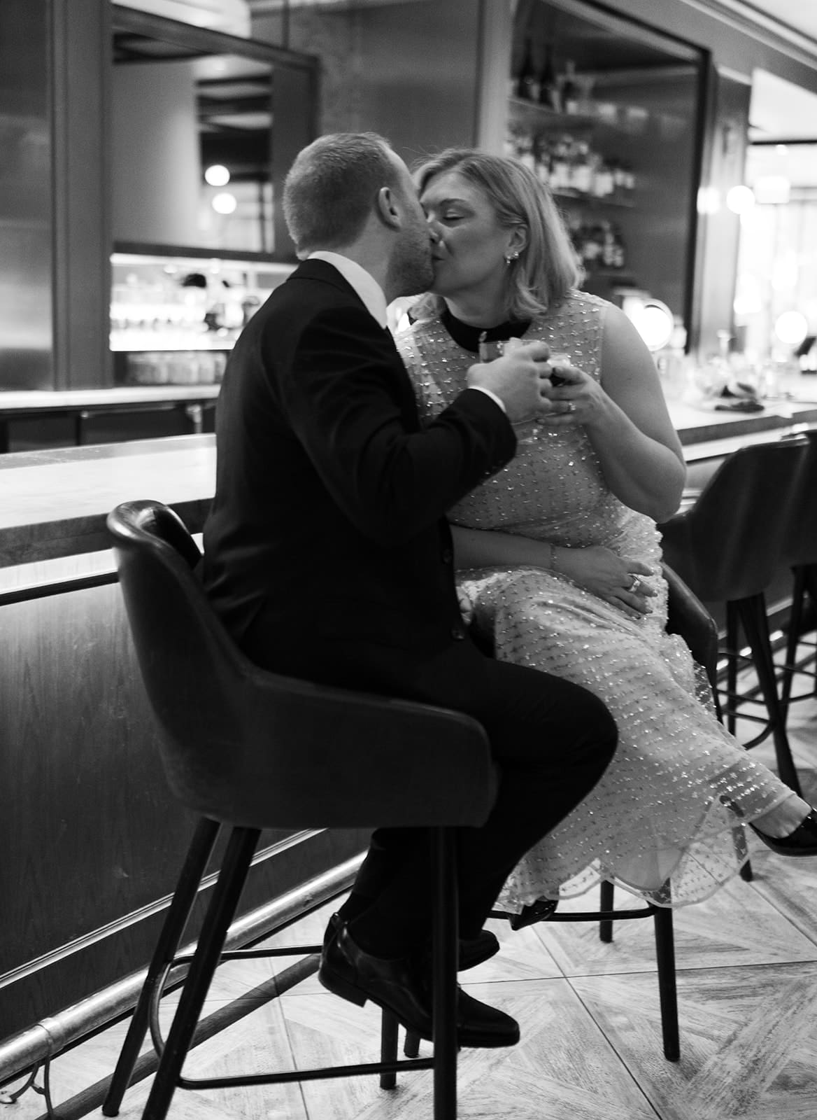 A black and white photo of a couple kissing in indoor engagement photos