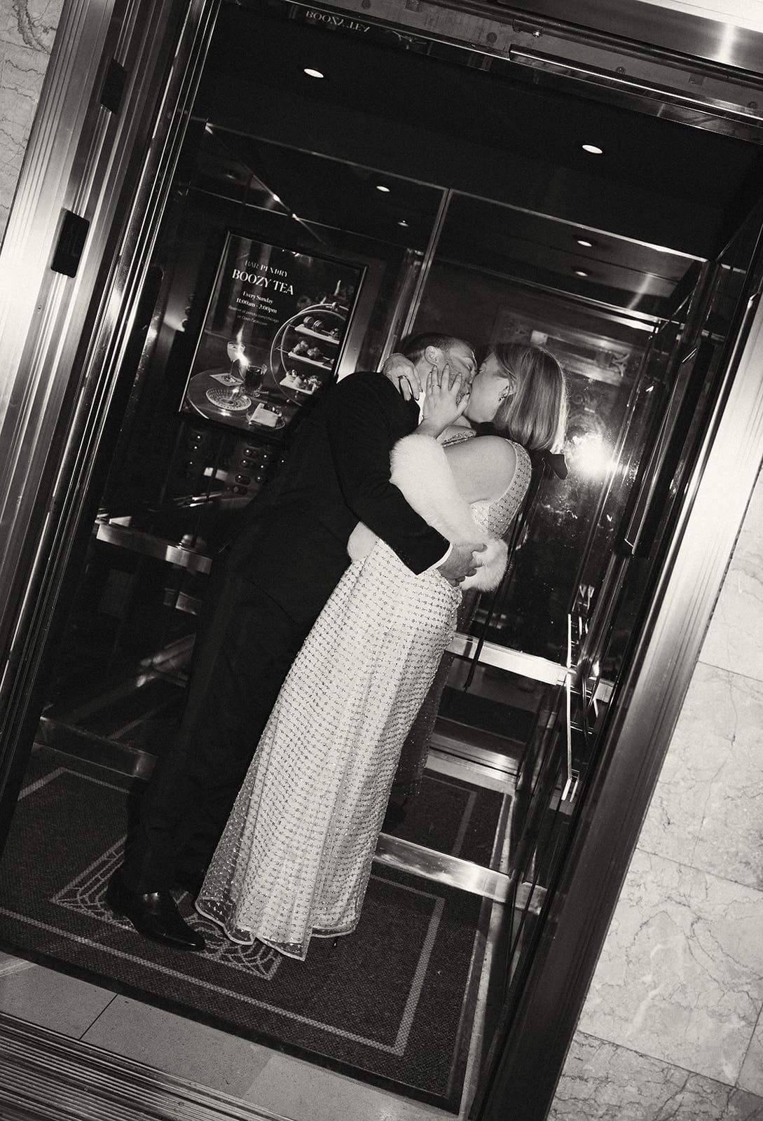 A black and white photo of a couple kissing in indoor engagement photos
