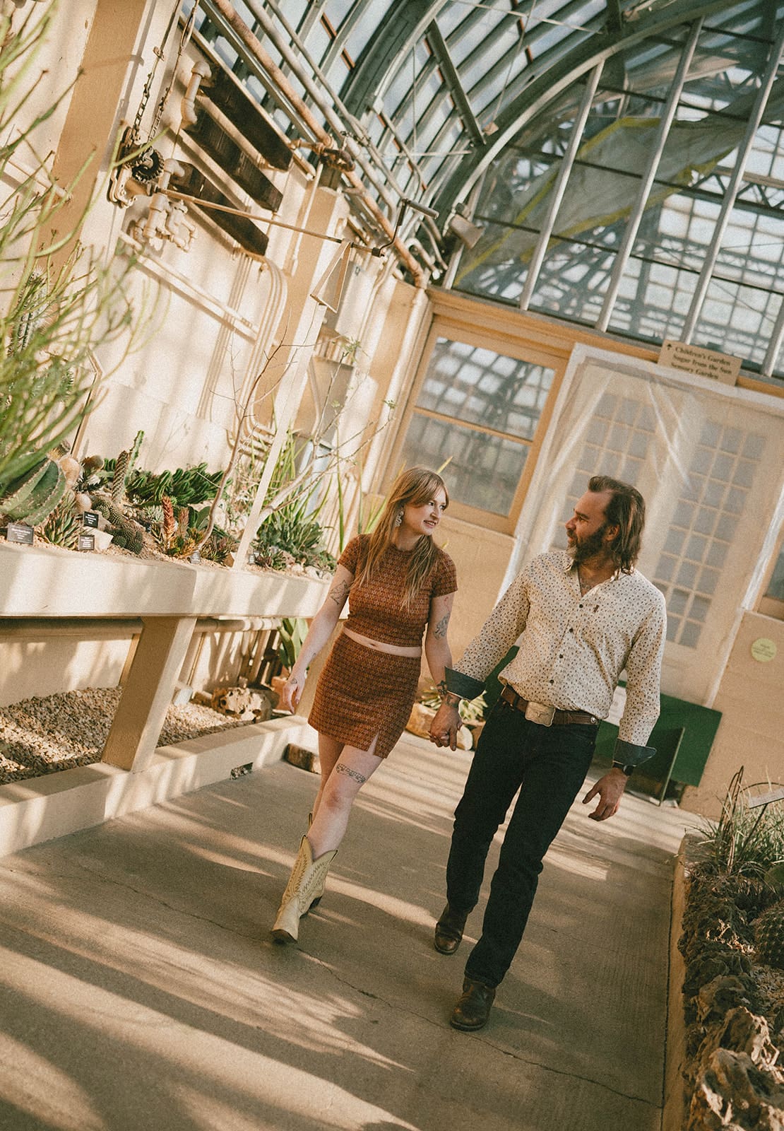 A couple taking engagement photos in a conservatory