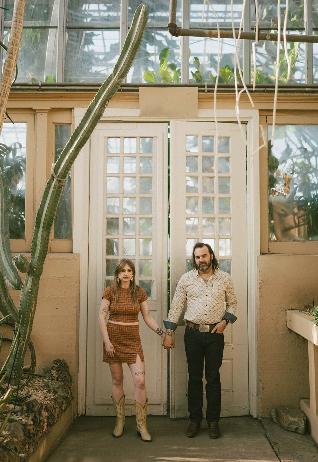 A couple taking engagement photos in a conservatory