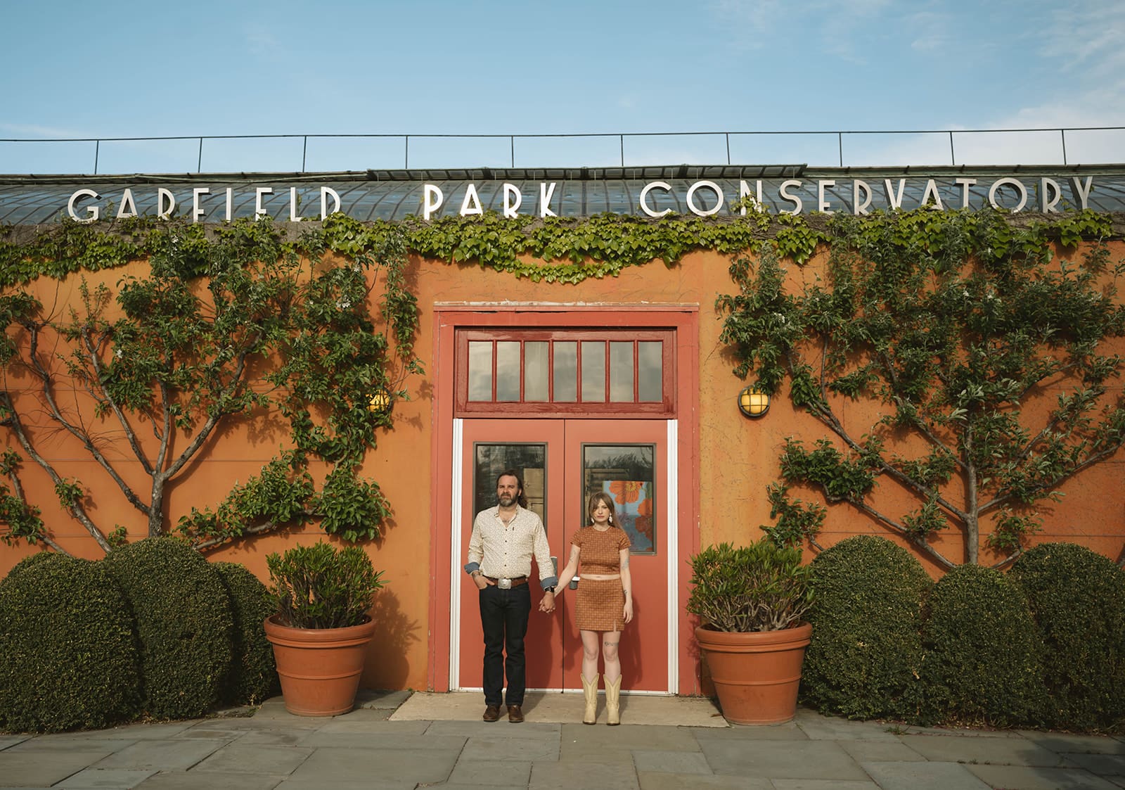A couple posing for photos who chose garfield park conservatory as their engagement photoshoot location