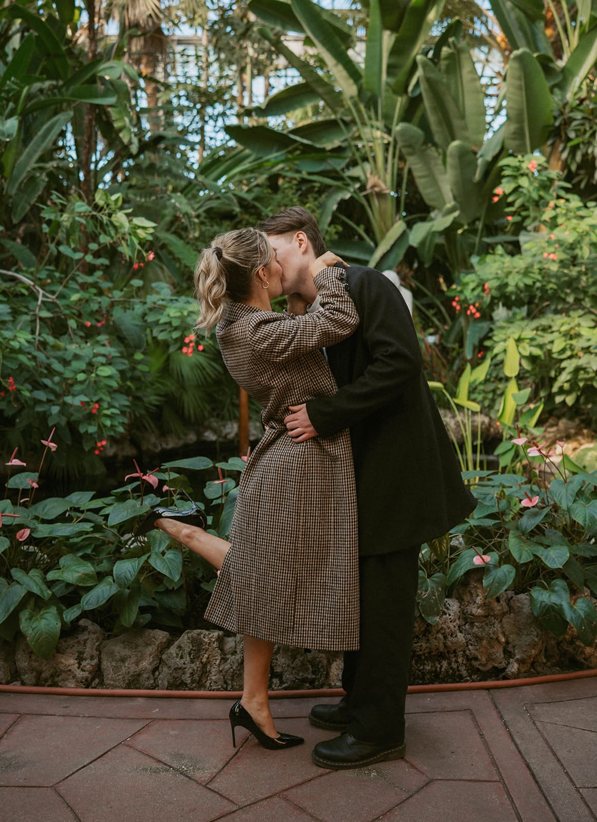A couple posing for engagement photos in a Conservatory
