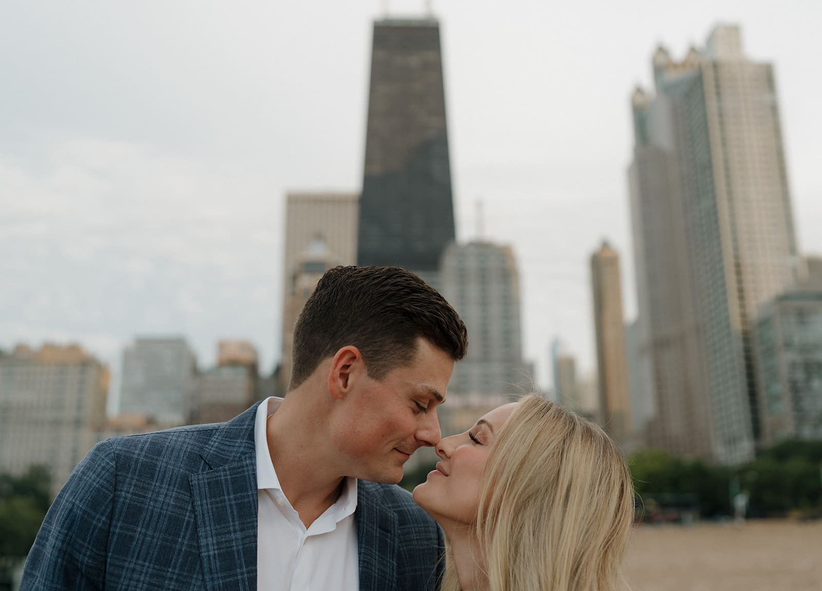 A couple kissing in front of the chicago skyline