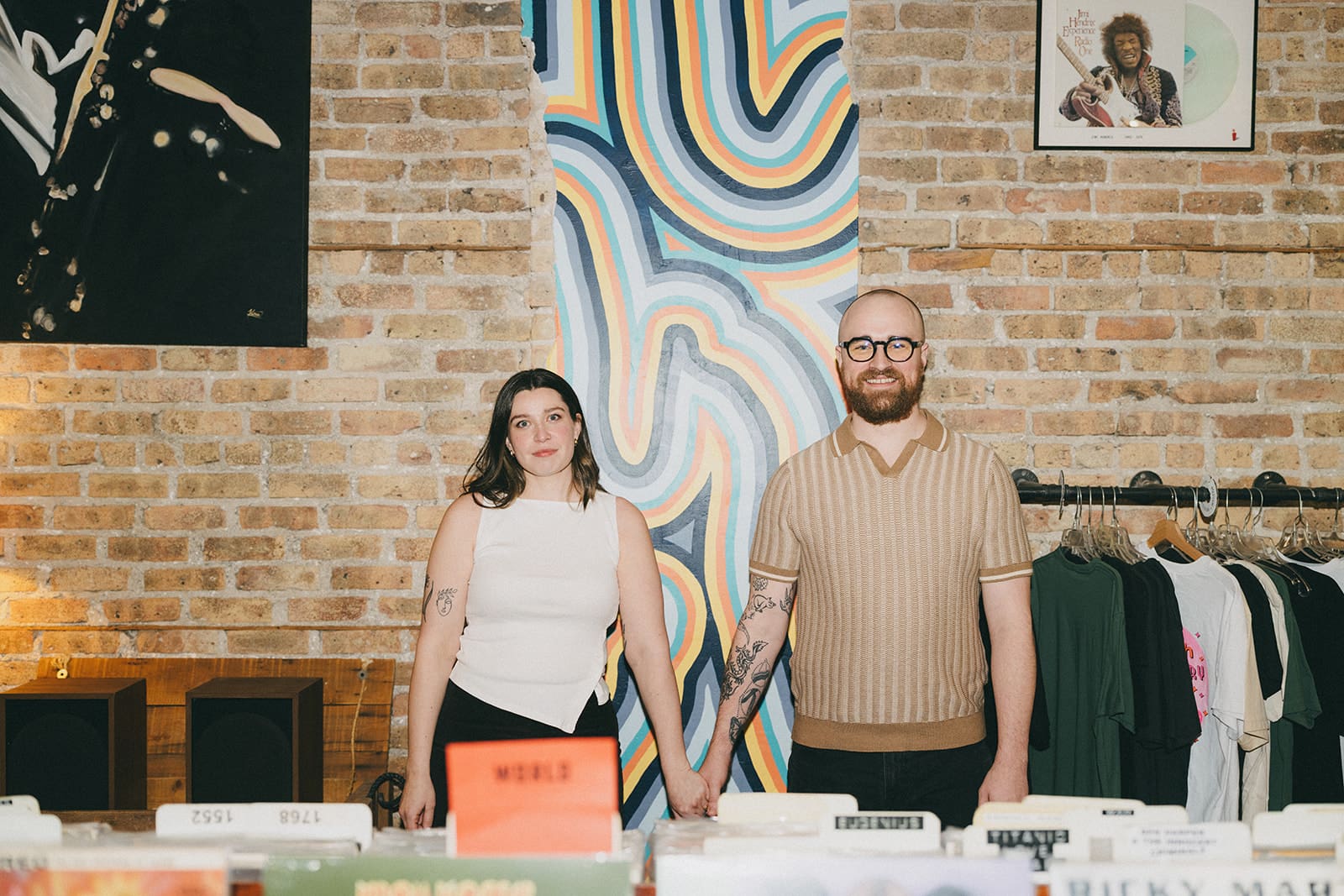 A couple in a record store as their engagement photoshoot lcoation