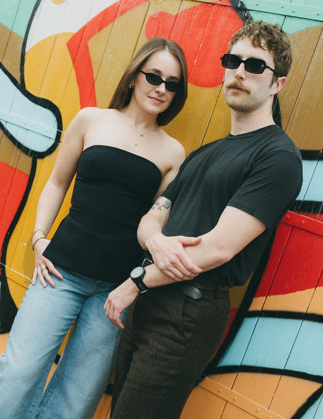 A couple taking engagement photos in front of a mural in Logan Square