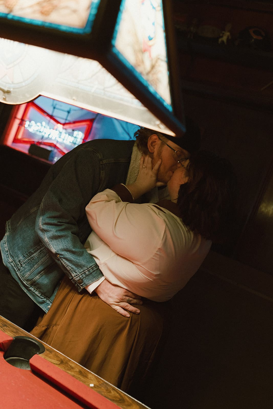 A couple kissing on a pool table during bar engagement photos