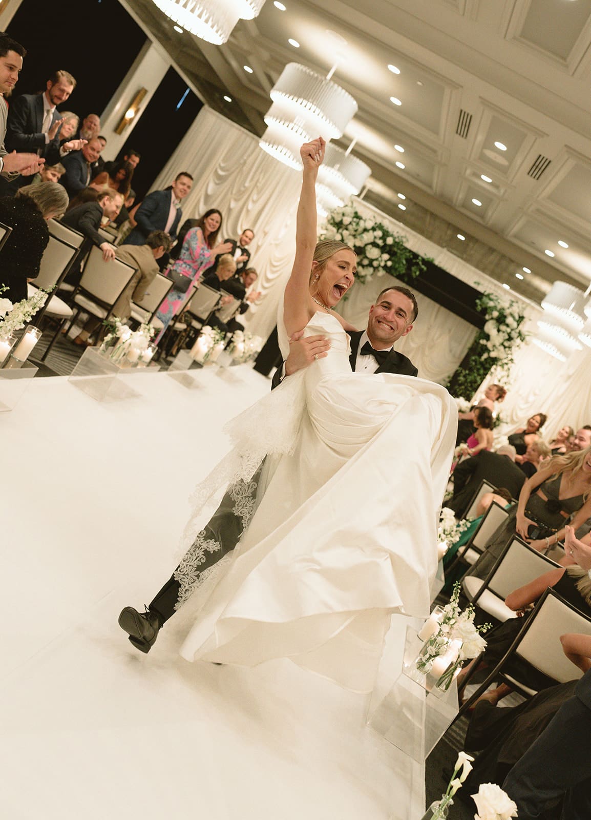 A bride and groom cheering after their wedding ceremony