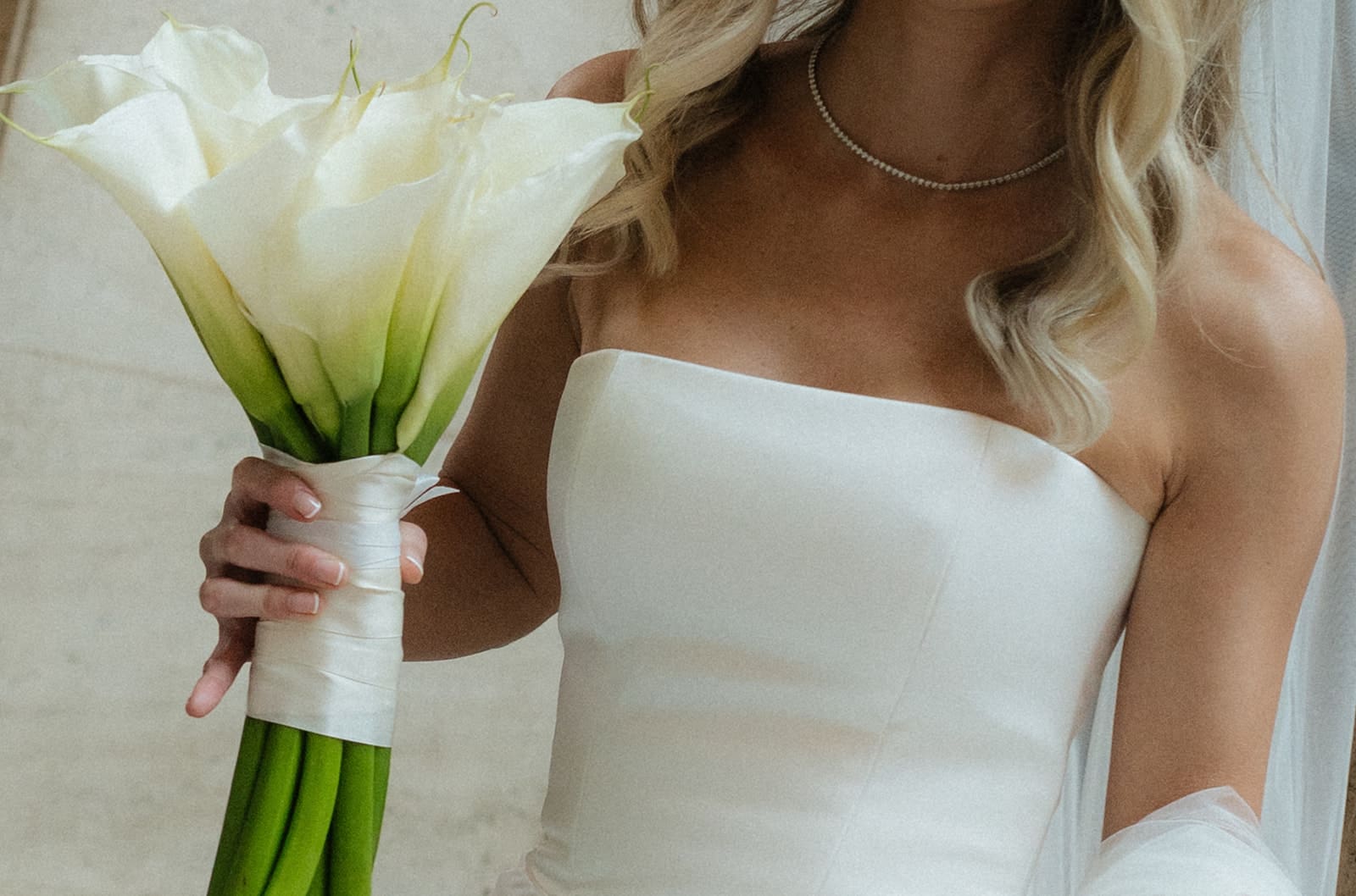 A bride holding a calla lily wedding bouquet, following the average Chicago wedding cost