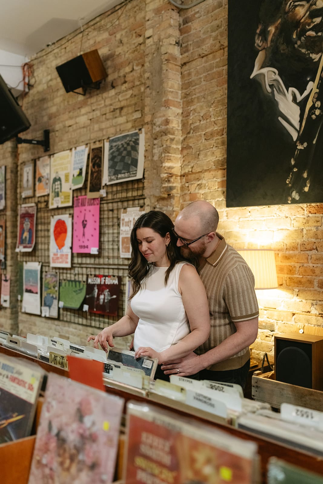 A couple looking through records during record store engagement photos