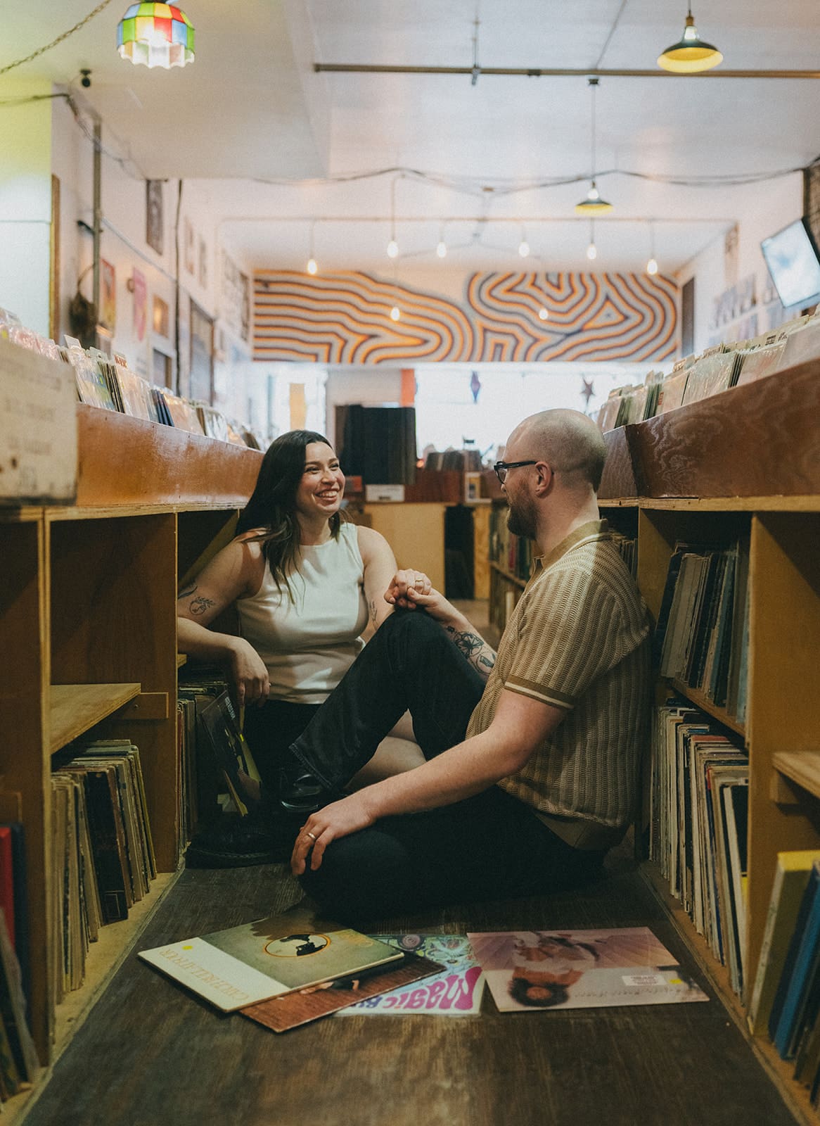 A couple sitting on the floor in a record store