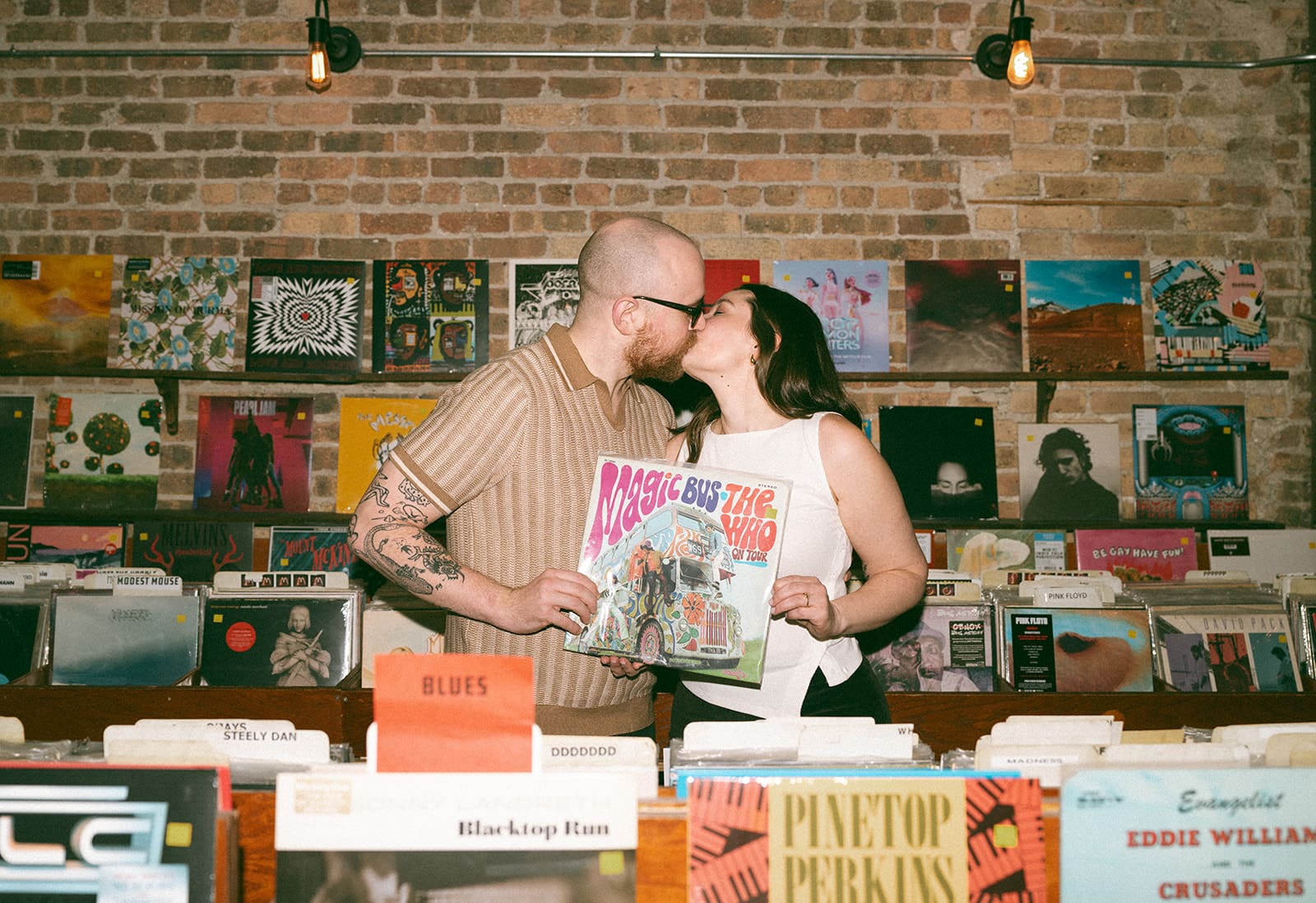 A couple kissing while holding a record