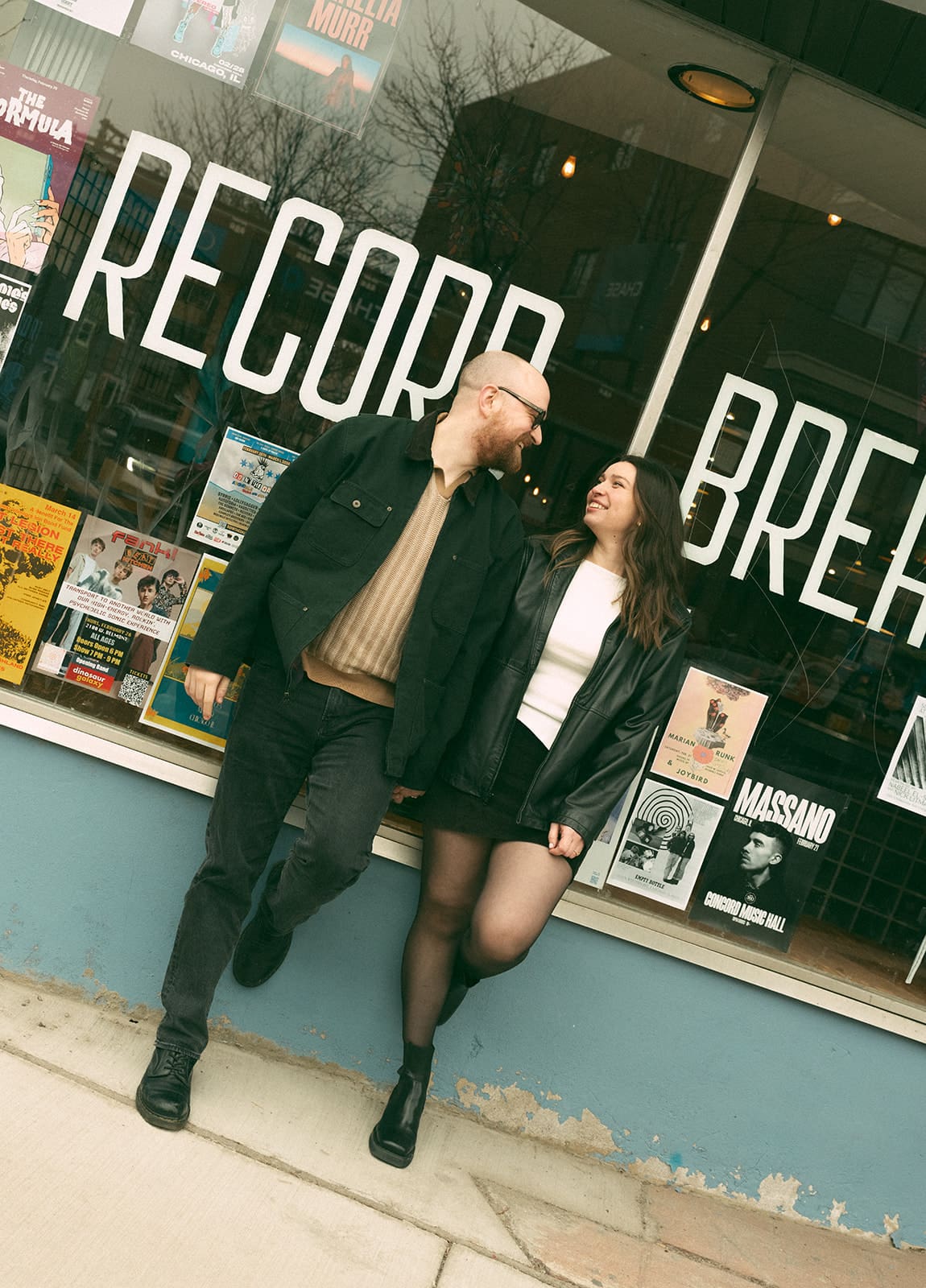 A couple at the record store they're taking engagement photos at