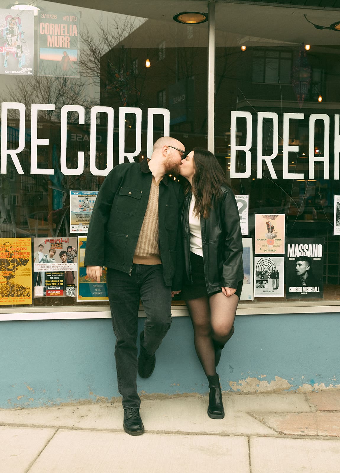 A couple at the record store they're taking engagement photos at