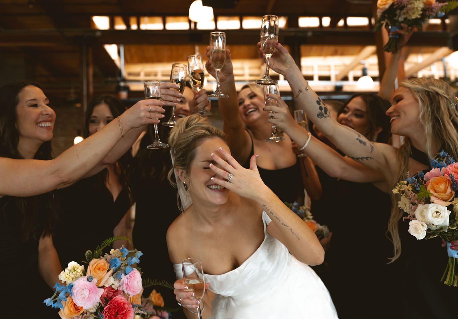 A bride cheering with her bridesmaids after the wedding ceremony part of her wedding planning timeline