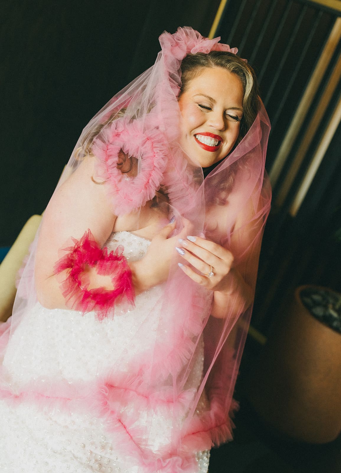 A bride in a unique wedding dress and pink wedding veil