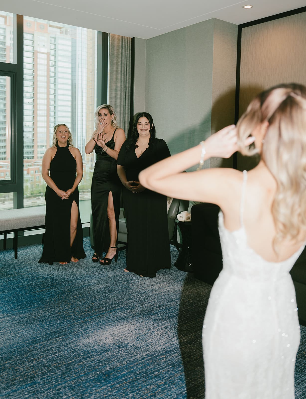 Bridesmaids reacting to a bride's wedding dress