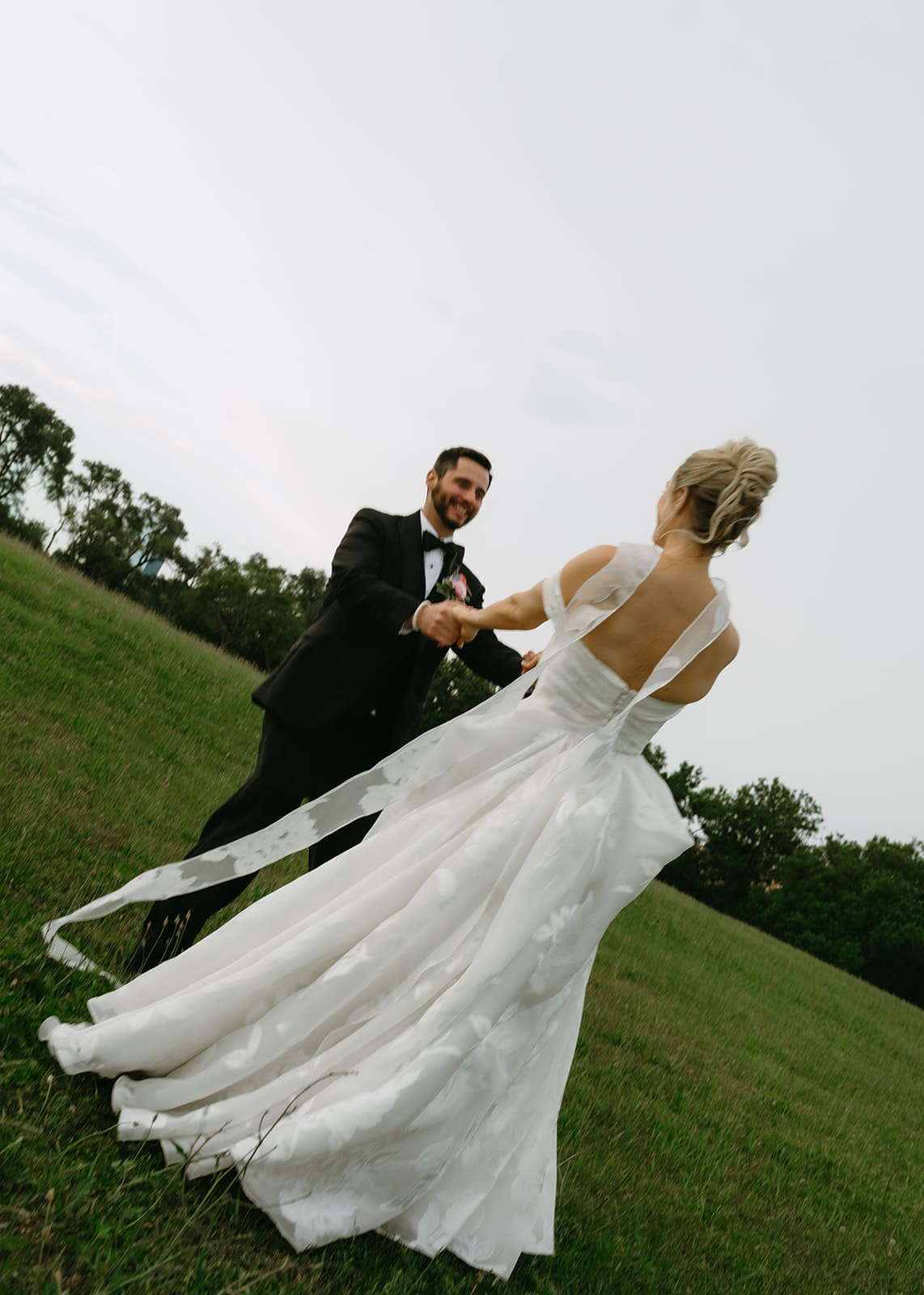 A bride and groom taking wedding photos in a field