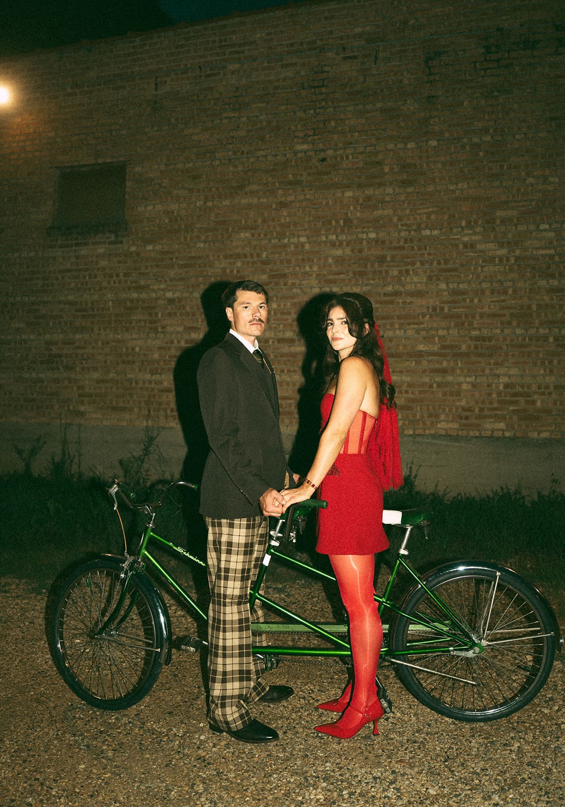 A bride and groom taking wedding photos on a double bike