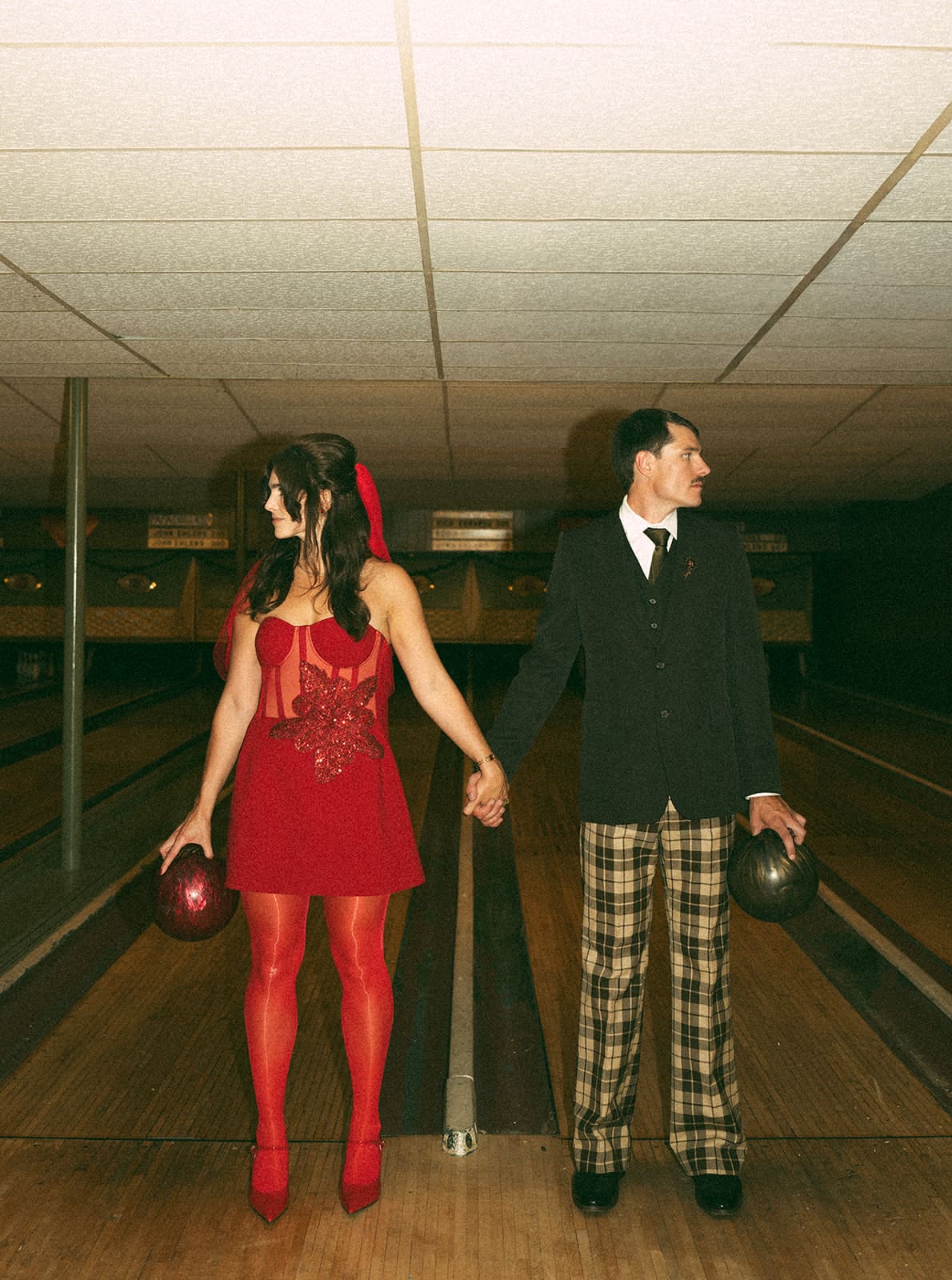 A bride and groom posing for photos at their funky wedding