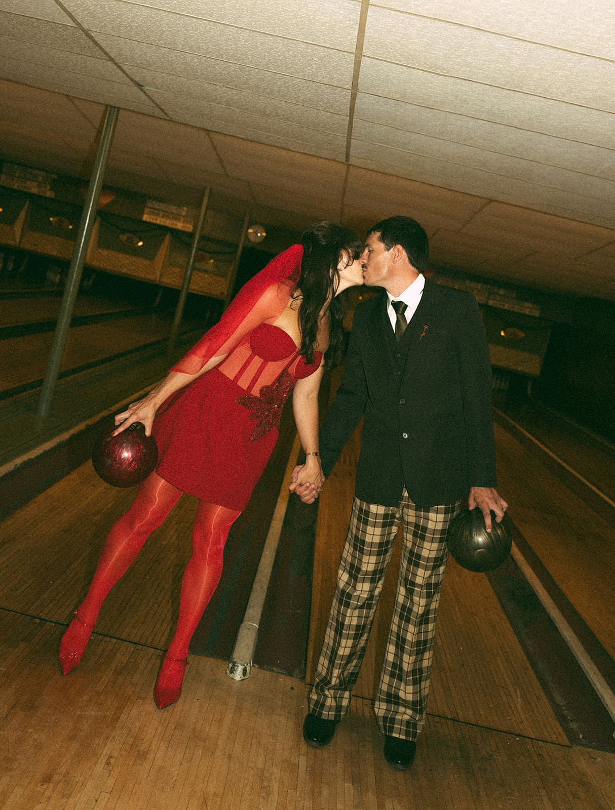 A bride and groom posing for photos at their funky wedding