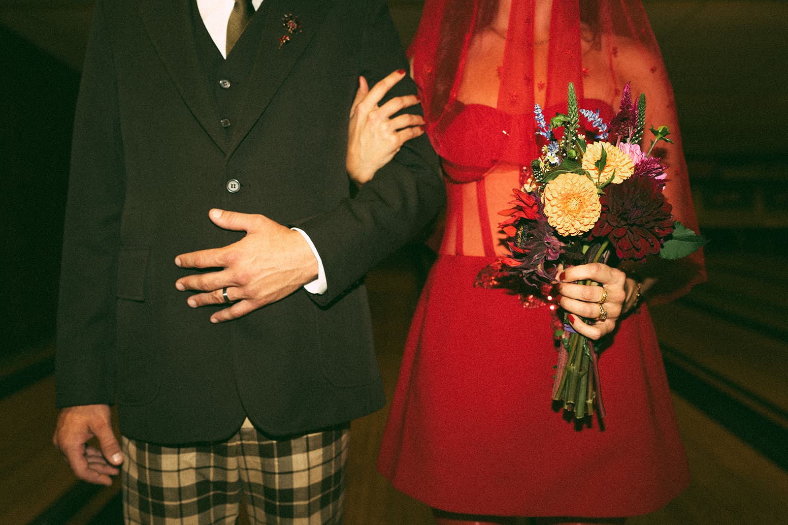 A bride and groom posing for photos at their funky wedding